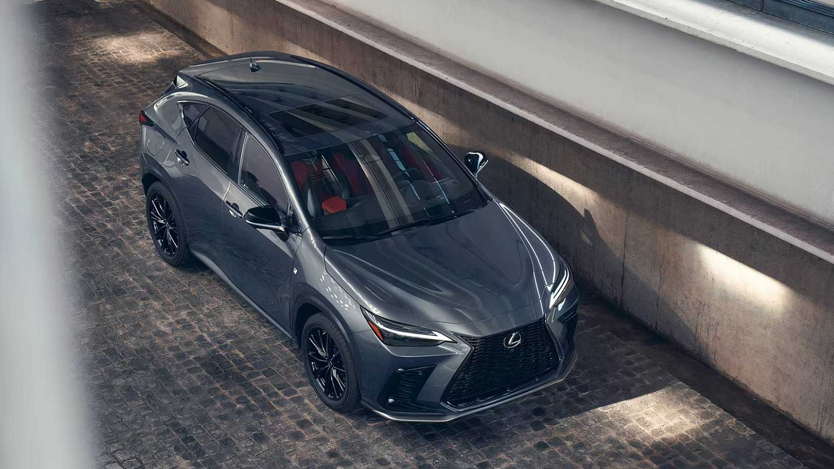 Um pequeno SUV híbrido Lexus NX Hybrid 2025 cinza estacionado na cidade