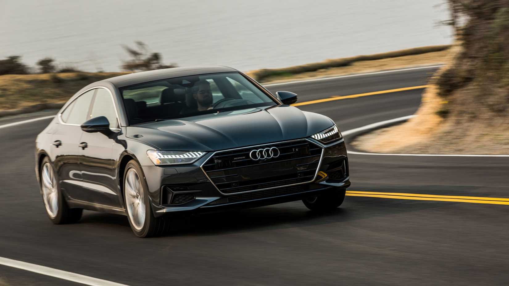 Front 3/4 action shot of a black 2021 Audi A7 speeding around a corner