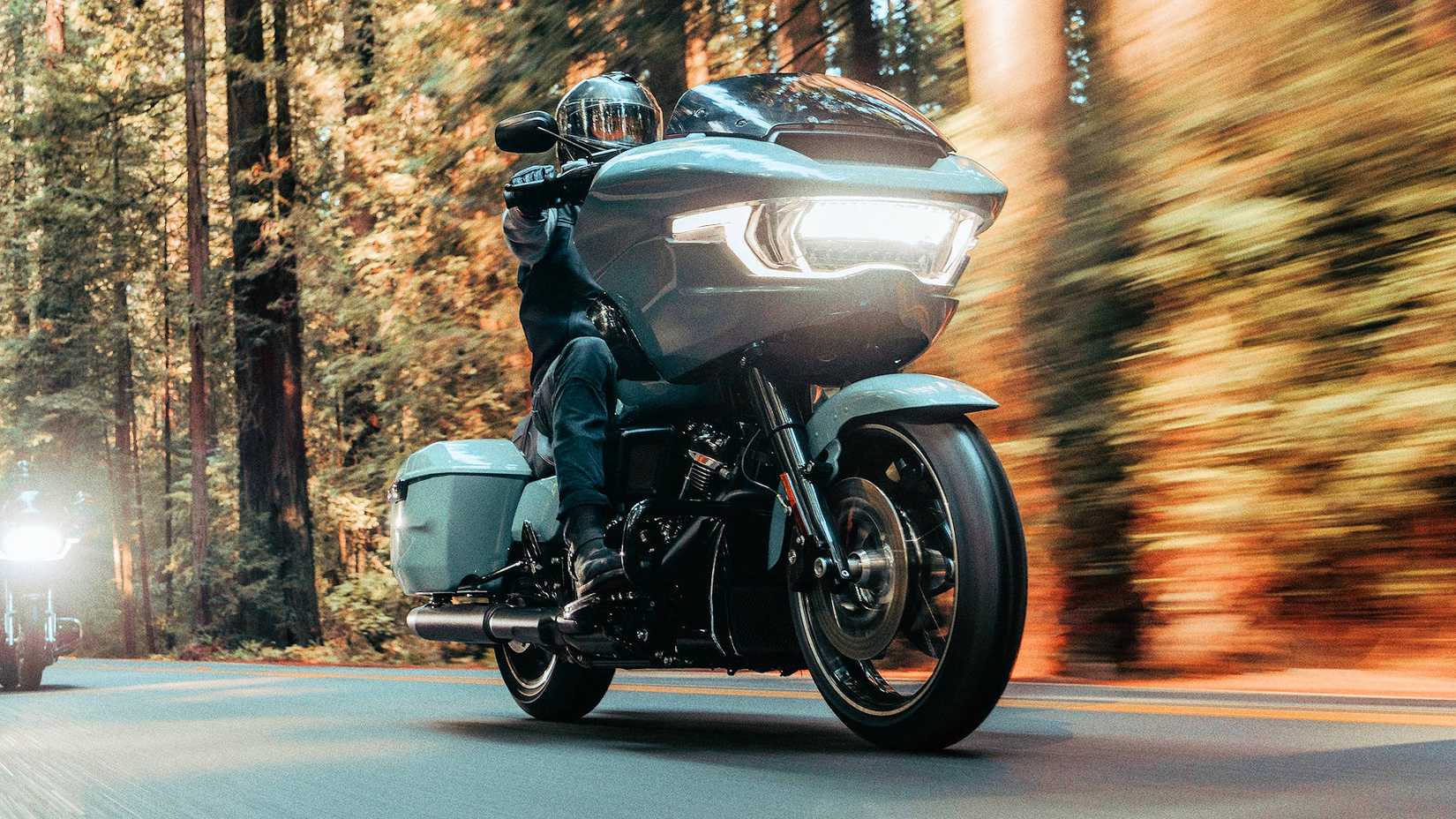 Piloto em uma Harley-Davidson Road Glide 2024 cruzando a floresta