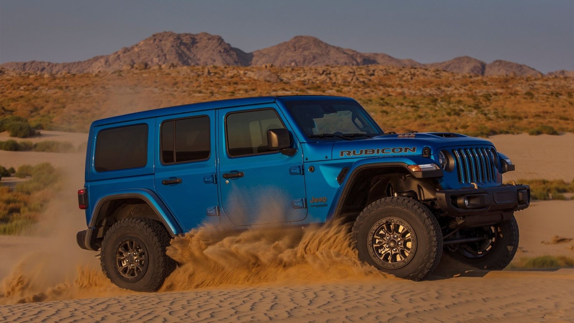 2024 Jeep Wrangler Rubicon in blue driving across desert