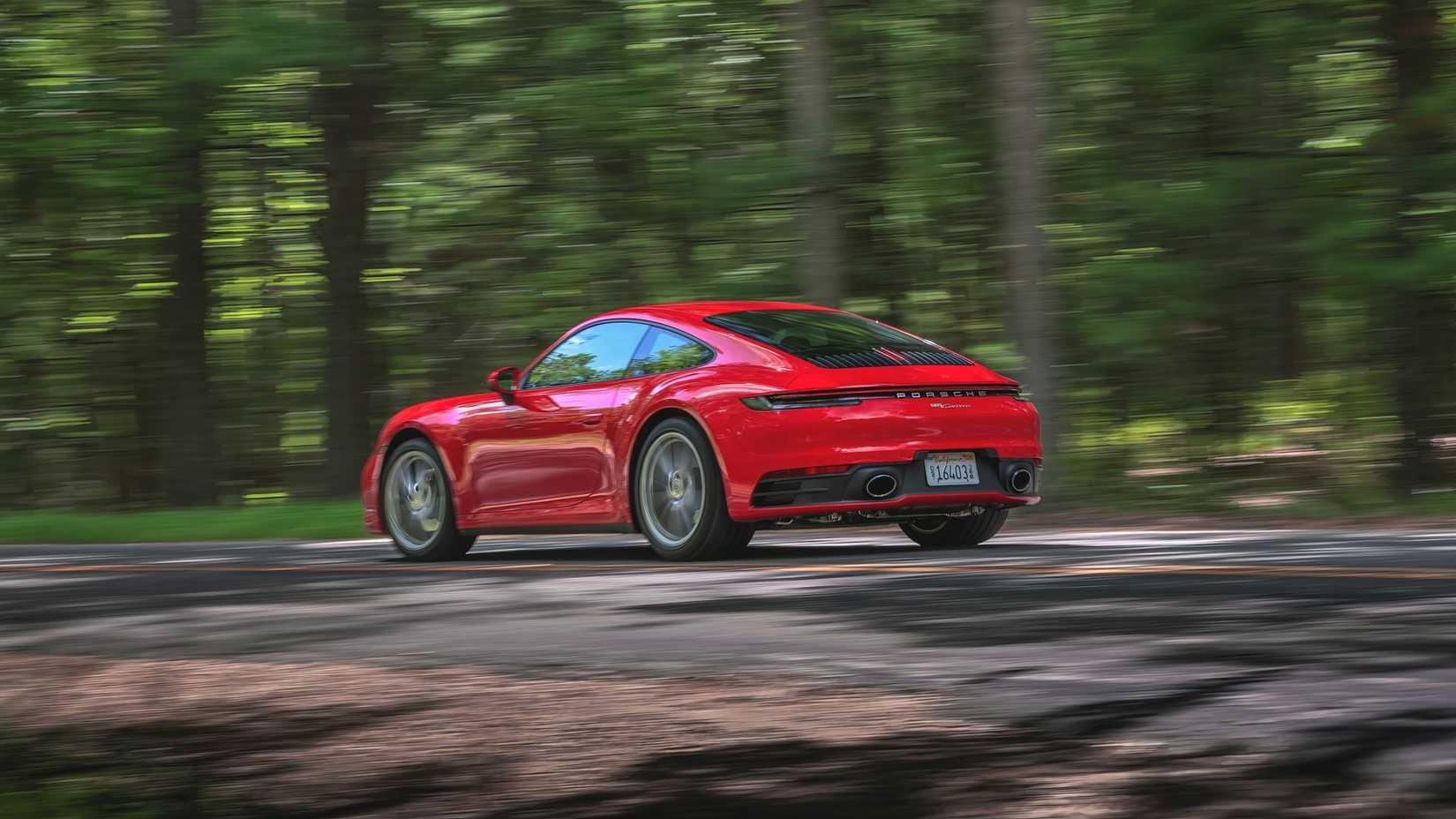 2024 Porsche 911 Carrera driving down a road