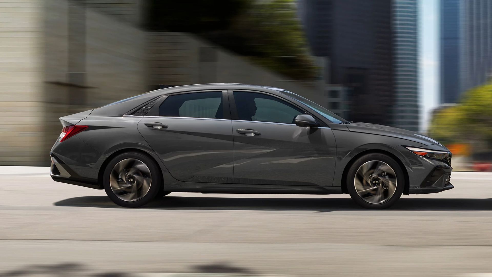 Side profile shot of a 2024 Hyundai Elantra Hybrid driving down the road