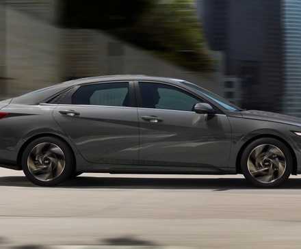 Foto lateral de um Hyundai Elantra Hybrid 2024 dirigindo na estrada