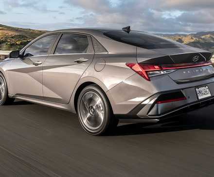 Uma foto traseira do lado esquerdo de um Hyundai Elantra 2024 acelerando na estrada