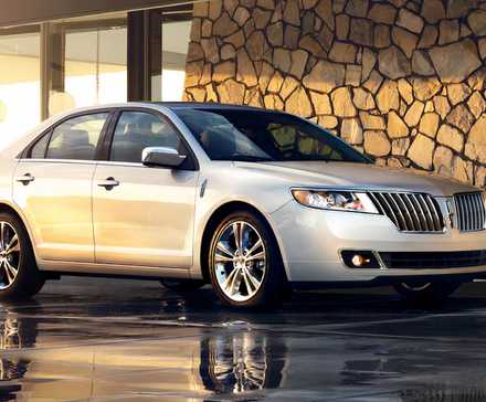 2012 Lincoln MKZ in silver posing on driveway of modern house