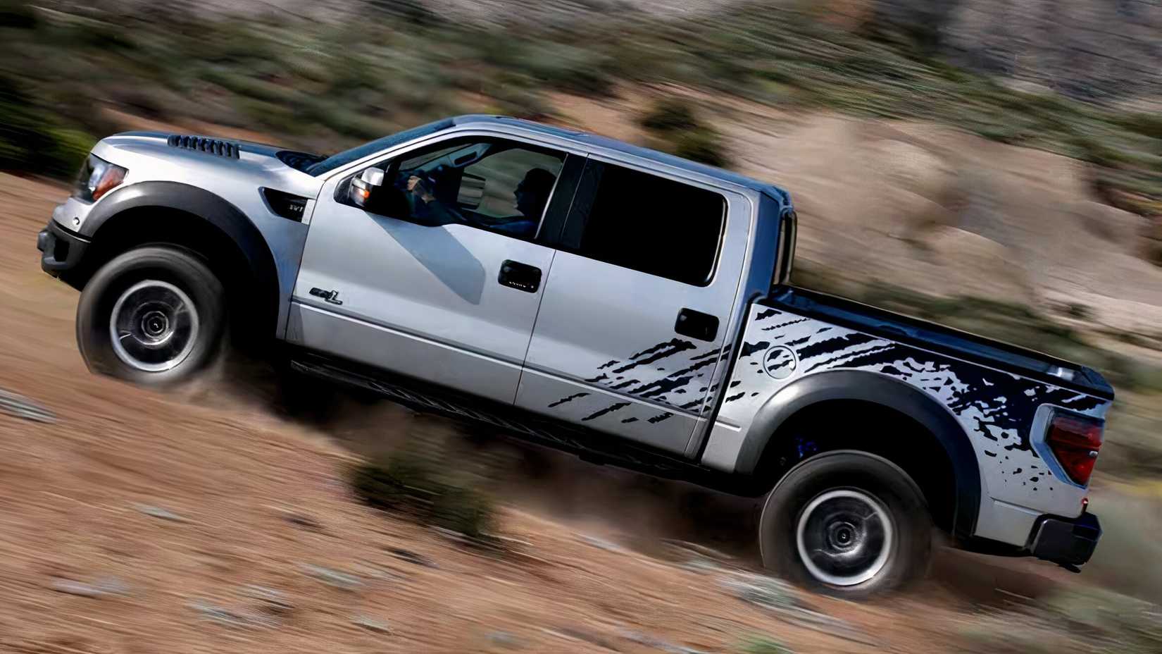 2011 Ford F-150 SVT Raptor Crew Cab in silver and black Driving up rocky and sandy terrain