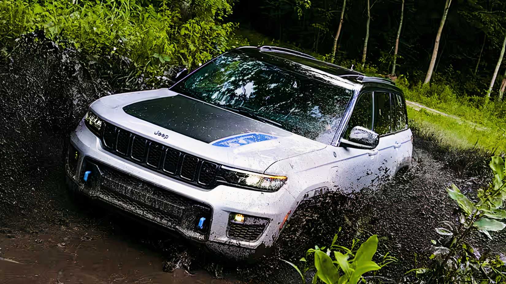 Um Jeep Grand Cherokee 4xe branco está dirigindo off-road.