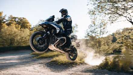Um piloto saltando com a BMW R 1300 GS 2024 em uma trilha