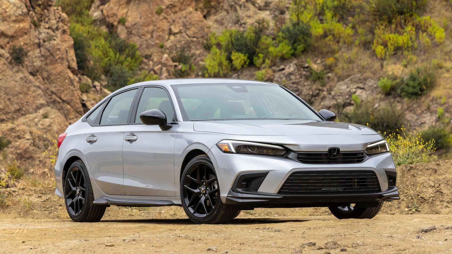 2024 Honda Civic Sedan Sport in silver posing off-road
