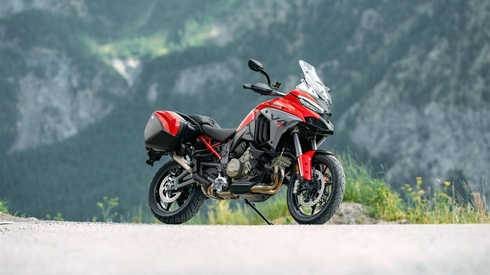 Una Ducati Multistrada V4 S in movimento su strada e terreno, con accessori e tecnologia avanzata