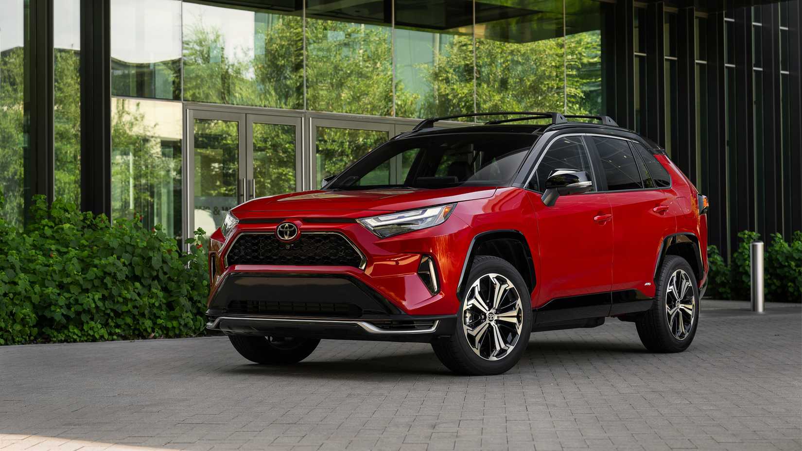 2025 Toyota RAV4 PHEV XSE Supersonic in red parked outside of office