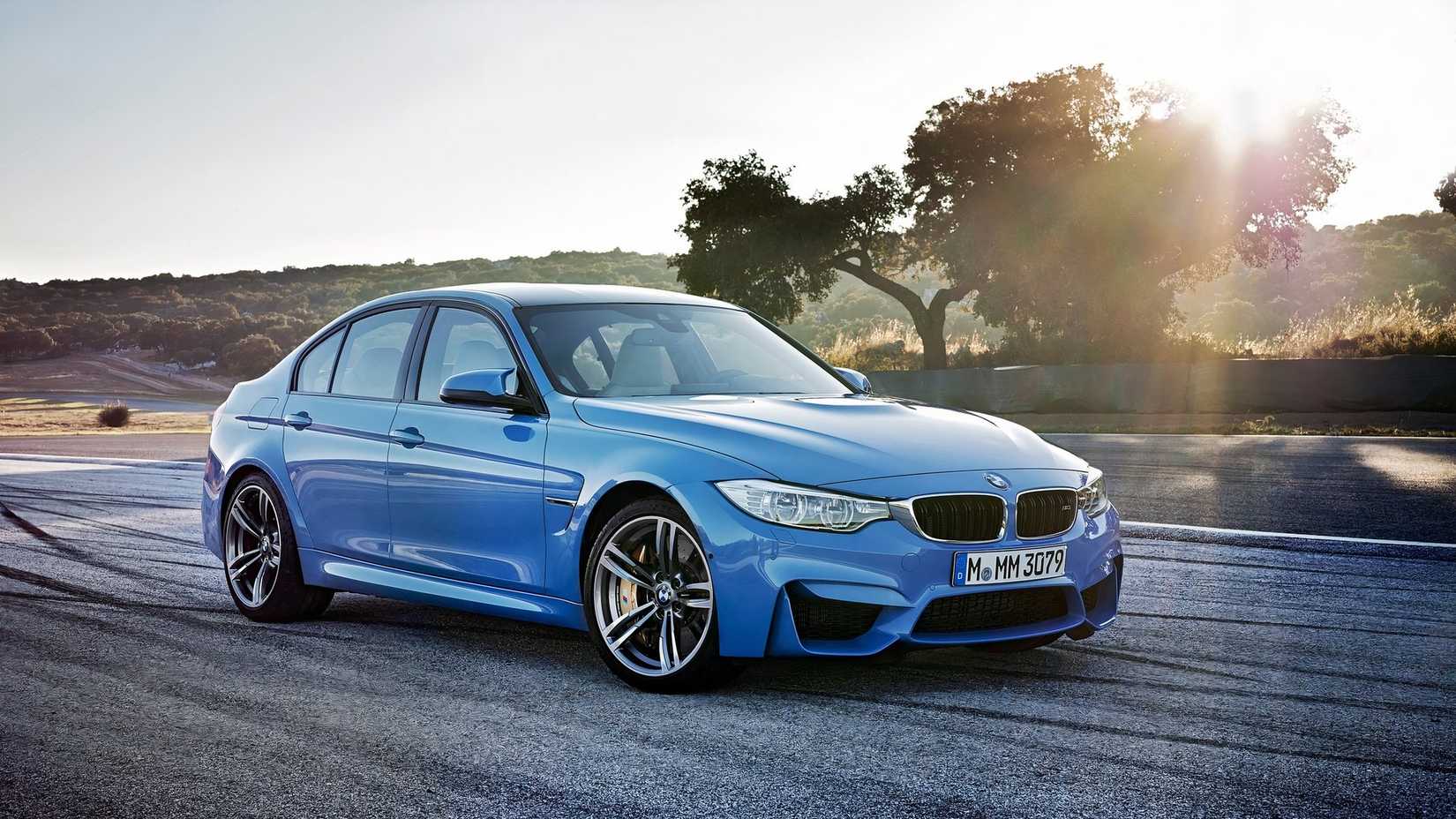 BMW M3 Sedan driving at sunset