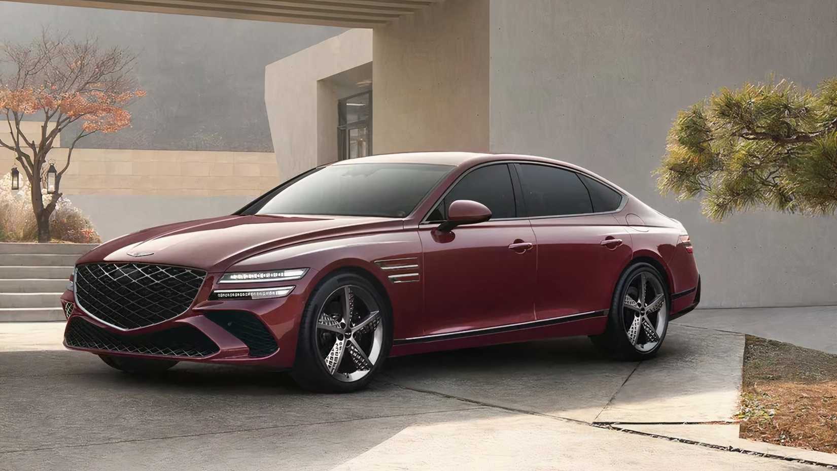2024 Genesis G80 in maroon posing outside of modern home