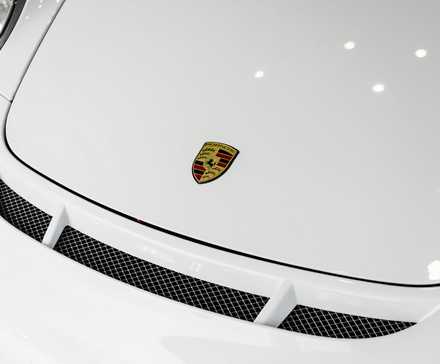 Porsche 997 GT3 RS 2011 com capô branco mostrando o emblema da Porsche