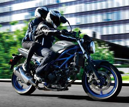 2023 Suzuki SV650 acelerando com o passageiro a bordo, vista frontal do terceiro quarto