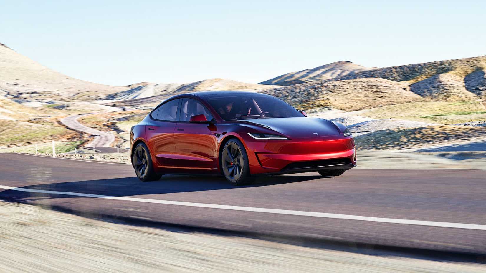 Um sedã elétrico Tesla Model 3 vermelho está circulando na estrada. 