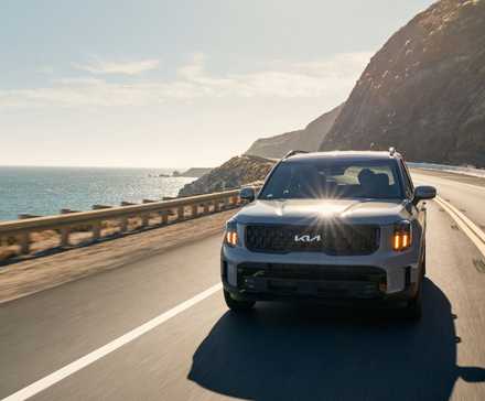 2025 Kia Telluride in green driving on coast road