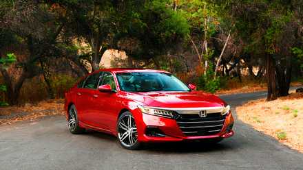 A red 2021 Honda Accord Hybrid midsize hybrid car is parked.
