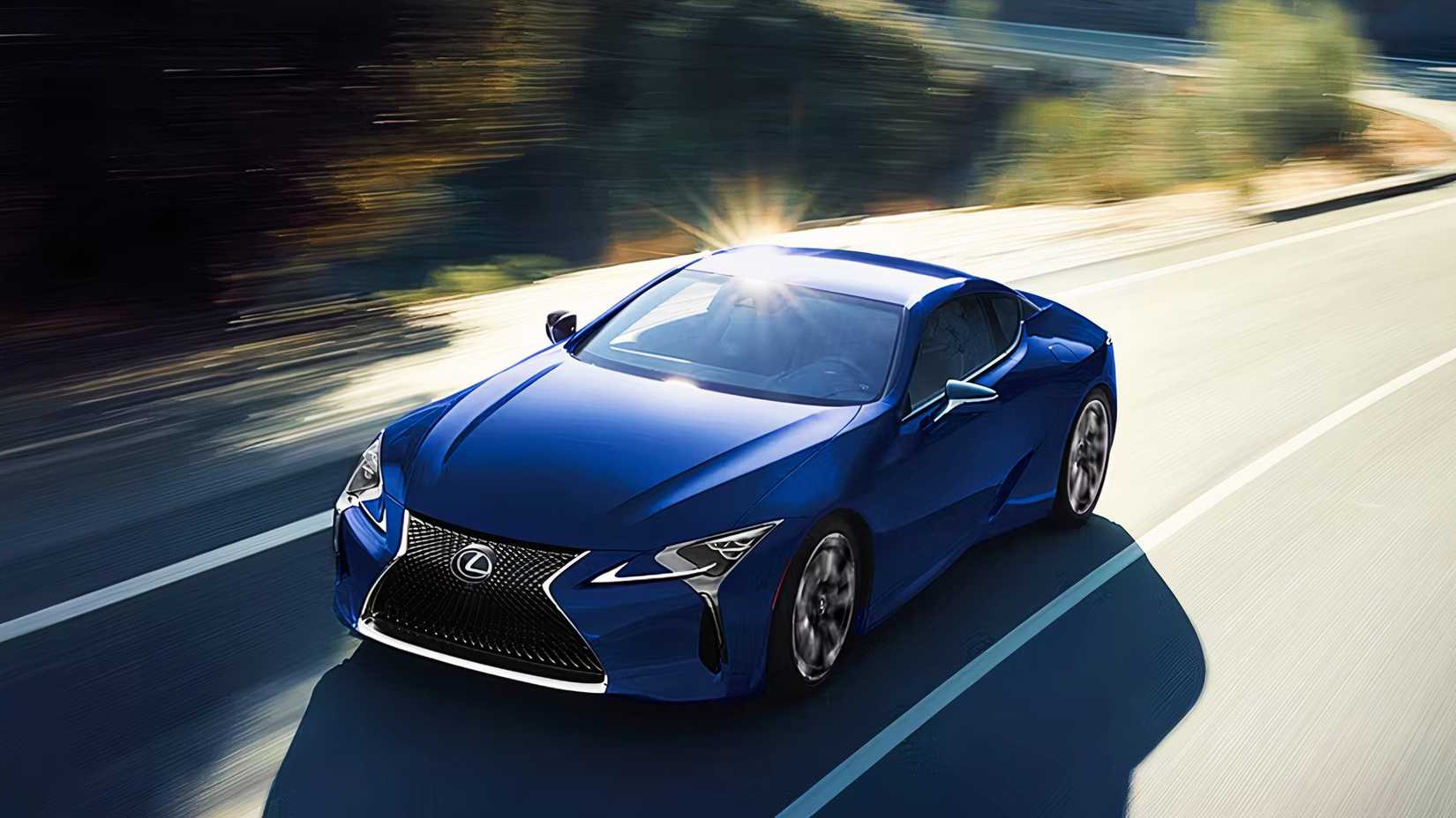 Um Lexus LC 500h azul 2024 está dirigindo na estrada.
