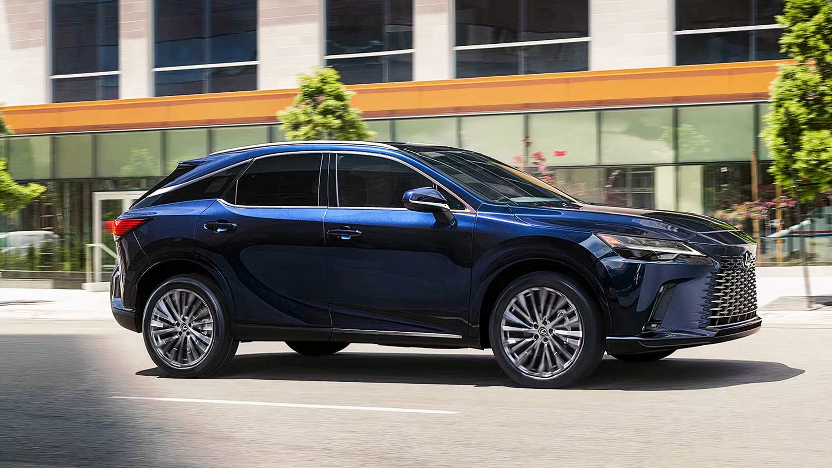 A blue 2024 Lexus RX 350h driving through a city