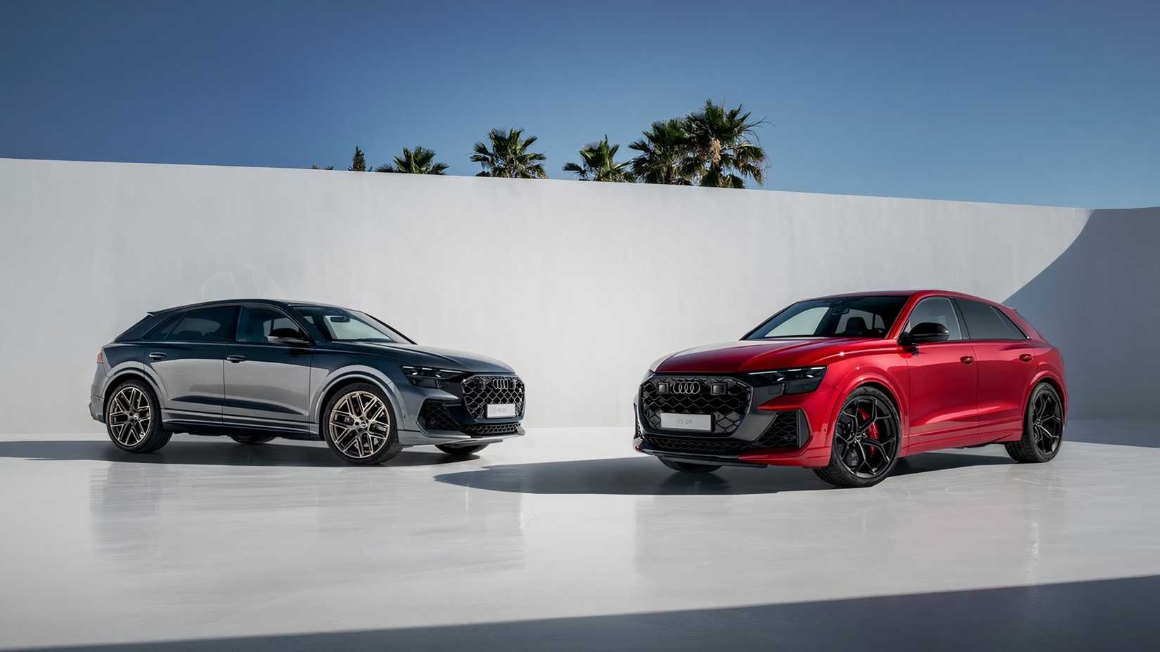 Front three-quarter view of a red and a gray Audi RS Q8 performance