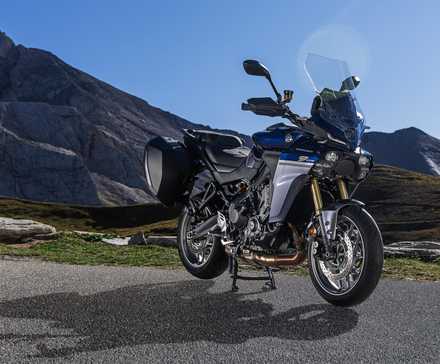 2025 Yamaha Tracer 9 GT frontal com ângulo de três quartos, estacionado na beira da estrada com montanhas como pano de fundo