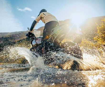 Piloto em uma Harley-Davidson Pan America 1250 Special 2024 chapinhando em um riacho