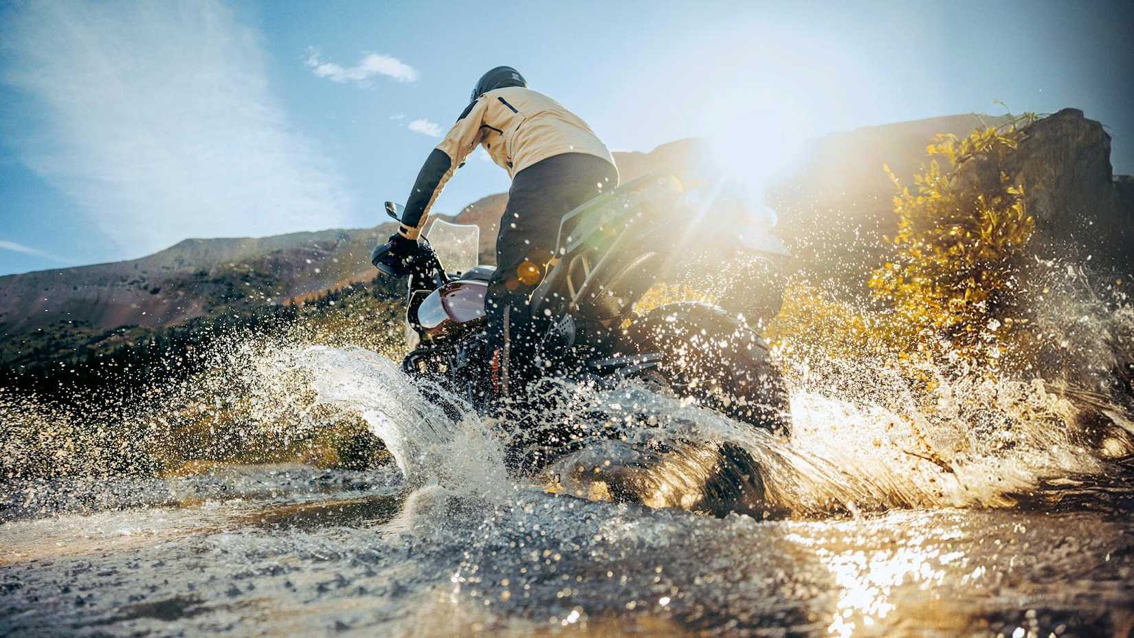 Piloto em uma Harley-Davidson Pan America 1250 Special 2024 chapinhando em um riacho