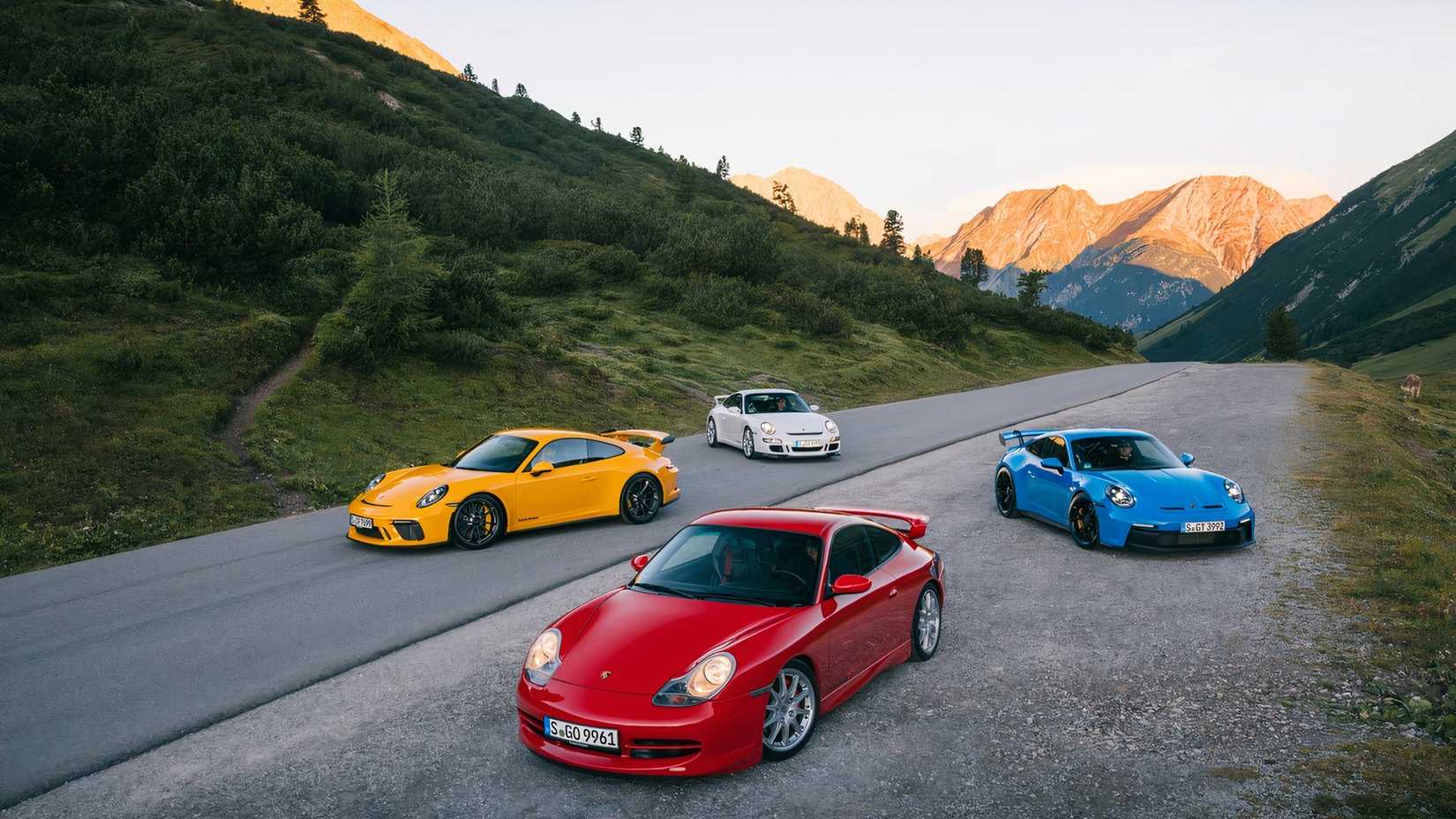 Gerações Porsche 911 GT3, carros dispostos em grupo na estrada de montanha