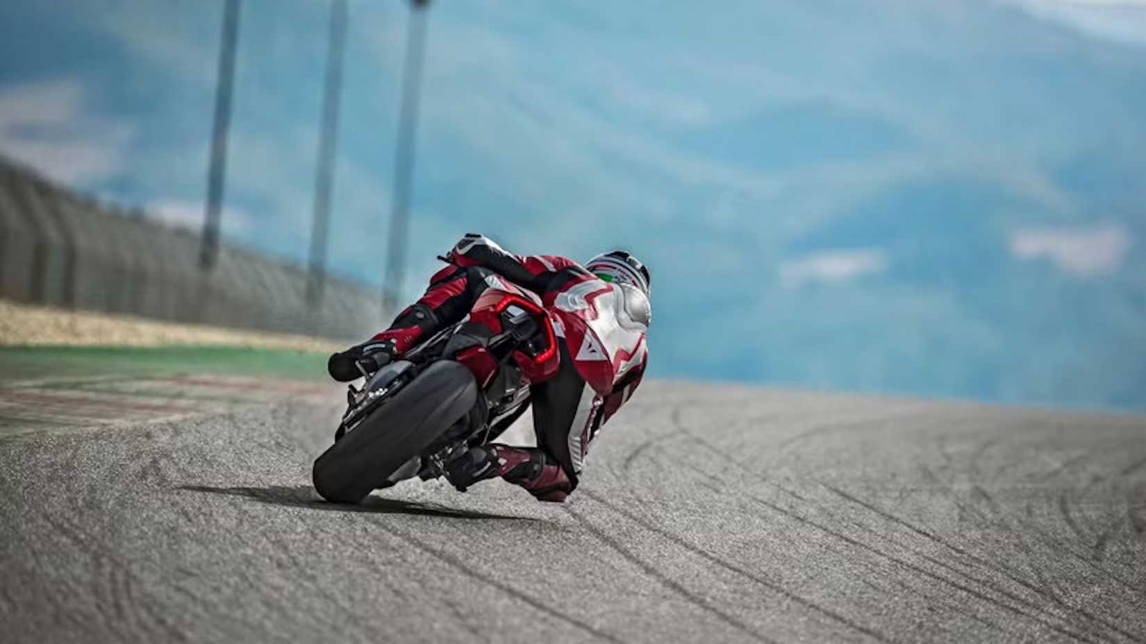 Foto traseira de um piloto fazendo curvas com uma Ducati Panigale V4 em uma pista de corrida