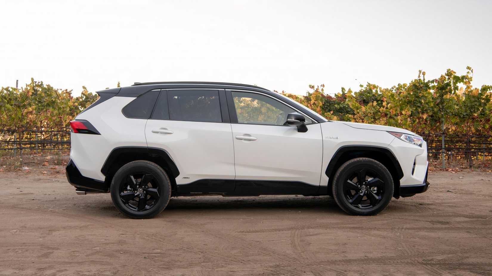 Side profile shot of a white 2021 Toyota RAV4 Hybrid XSE