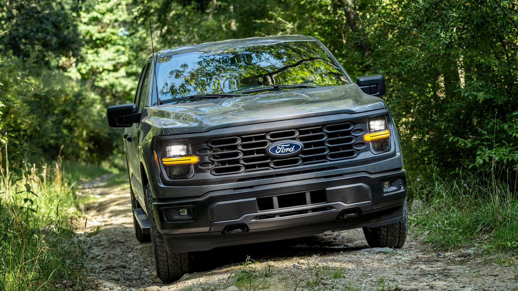 2024 Ford F-150 STX in gray being driven off-road