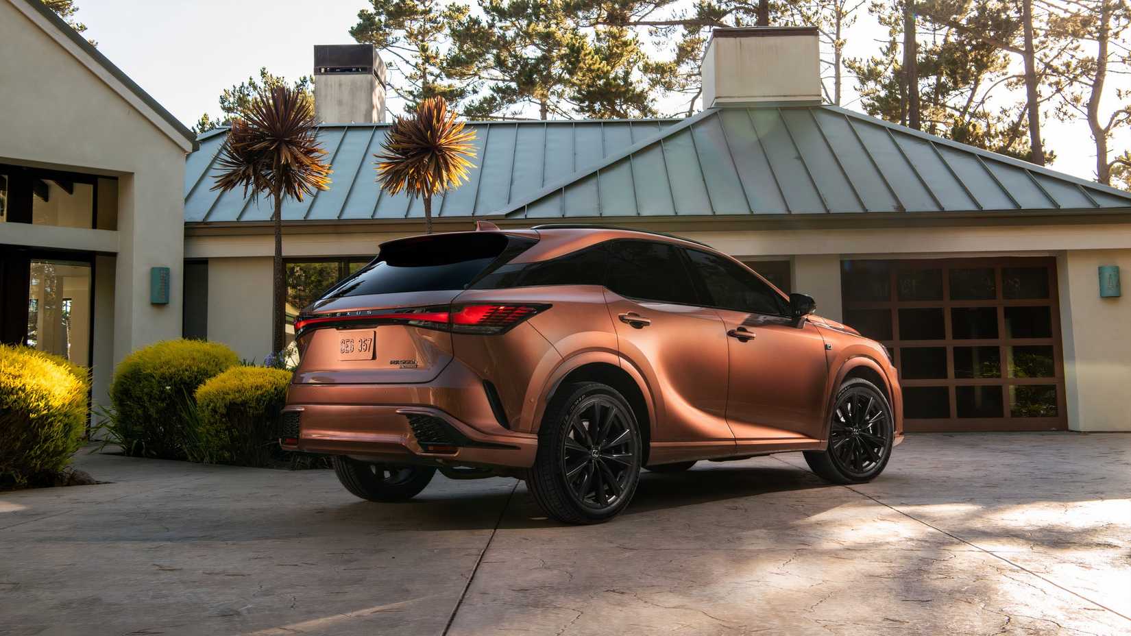Foto traseira de três quartos de um Lexus RX 500h FSPORT Performance AWD 2025 de cobre