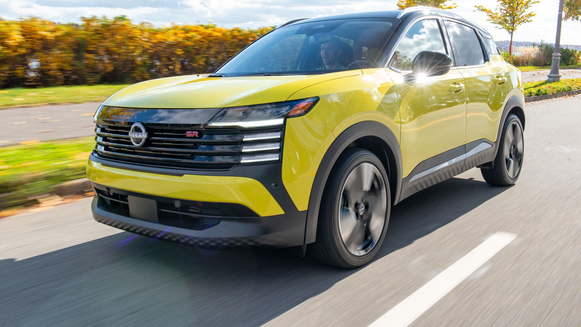 2025 Nissan Kicks SR AWD in yellow front view driving
