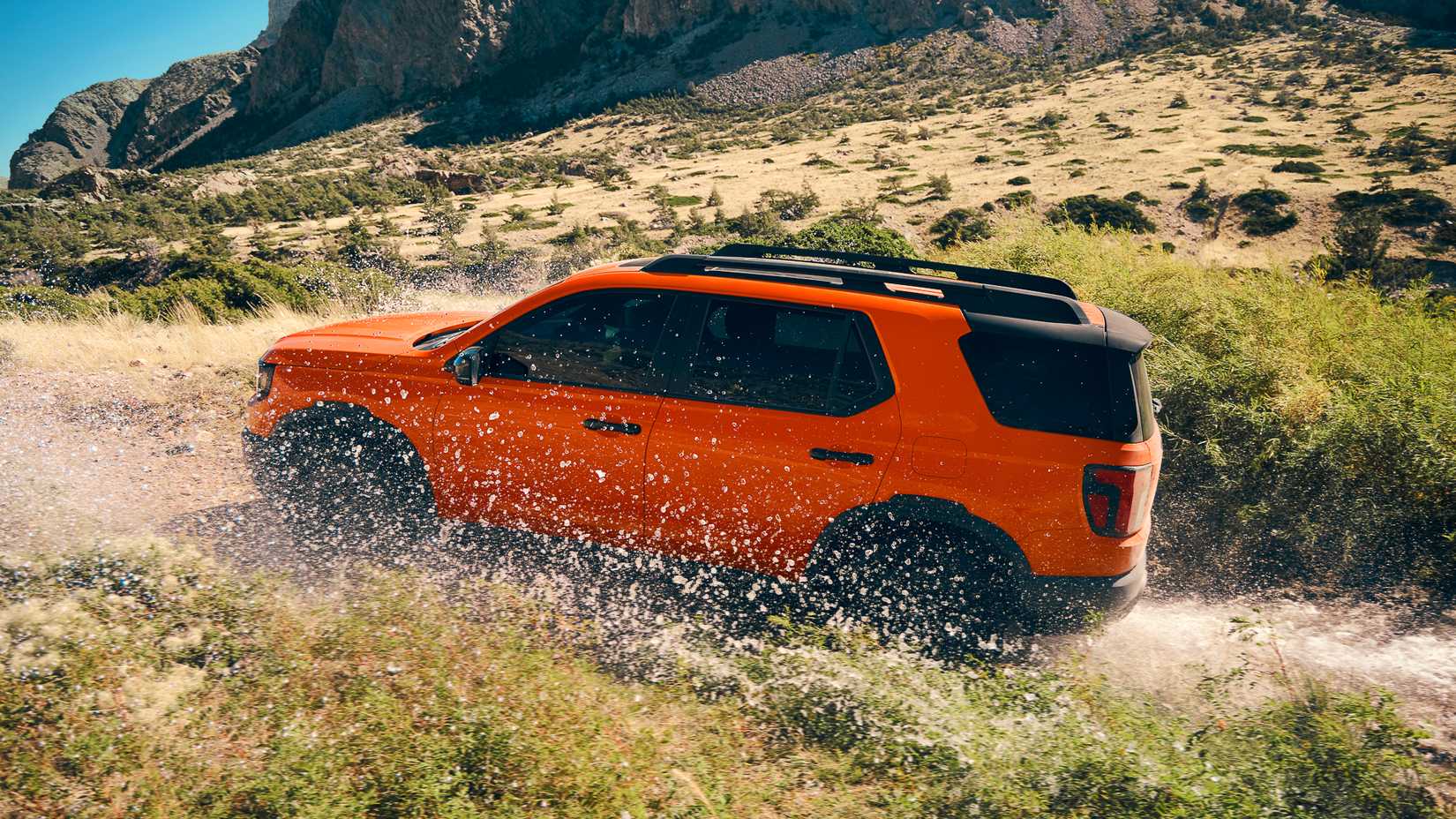 Um Honda Passport 2026 laranja sobe uma colina em uma trilha