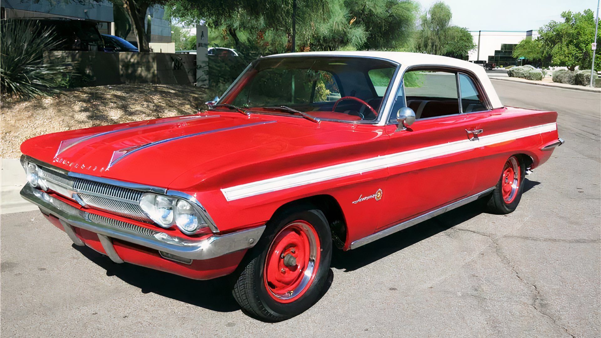 1962 Oldsmobile Jetfire in red posing on street