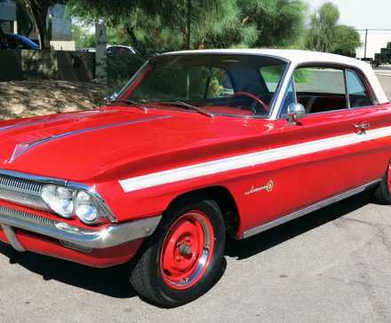 Oldsmobile Jetfire 1962 em vermelho posando na rua
