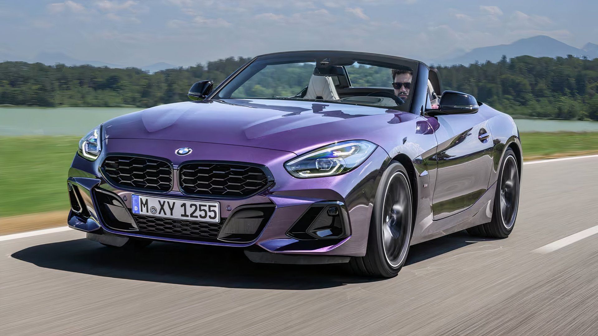 2025 BMW Z4 M40i in purple driving along country road with convertible roof down