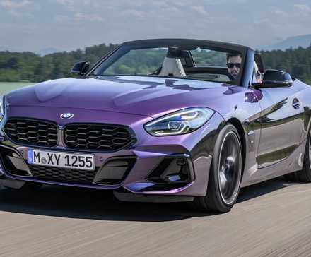 2025 BMW Z4 M40i in purple driving along country road with convertible roof down
