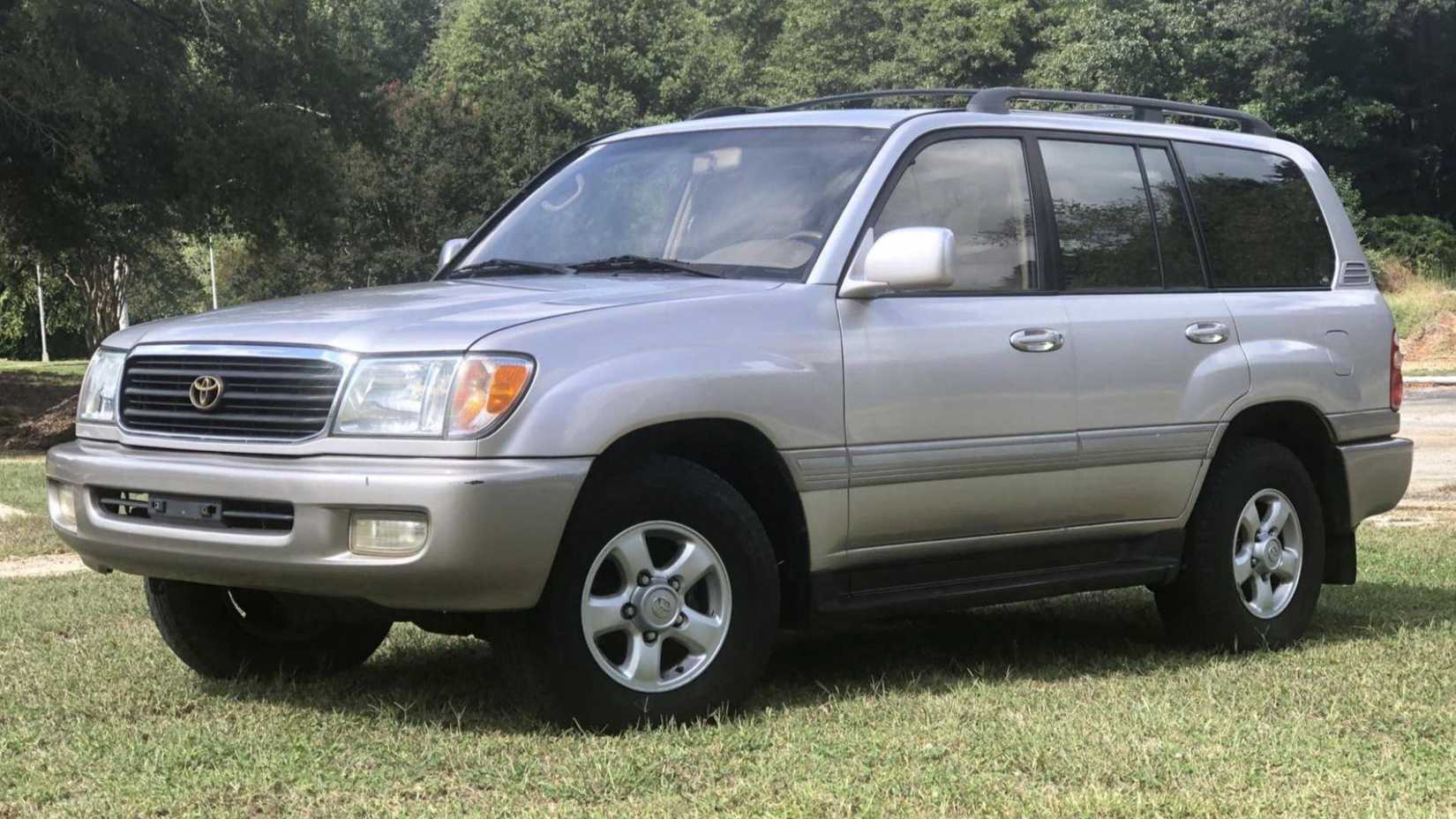 Toyota Land Cruiser 1999 em prata estacionado na grama