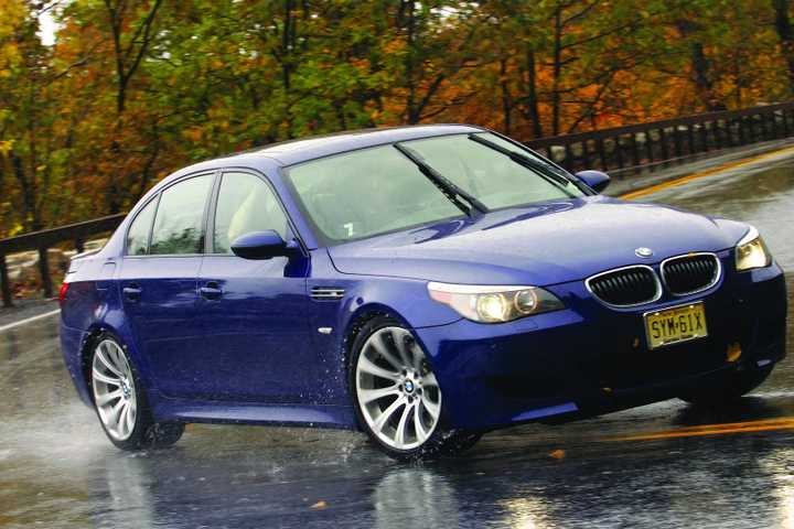 2006 BMW M5 in blue driving on wet road