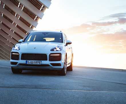 Um Porsche Cayenne E Hybrid 2019 branco está estacionado.