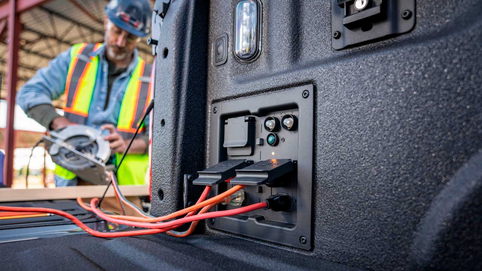 Foto traseira do Ford F-150 Hybrid 2021 mostrando saídas de caçamba em uso