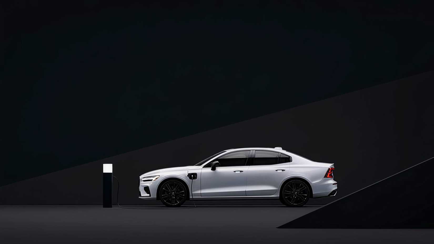A white 2022 Volvo S60 Recharge plug-in hybrid is charging. 