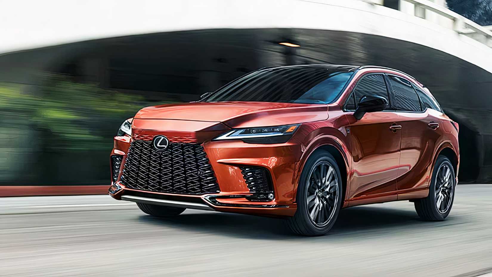An orange 2025 Lexus RX Hybrid is driving. 
