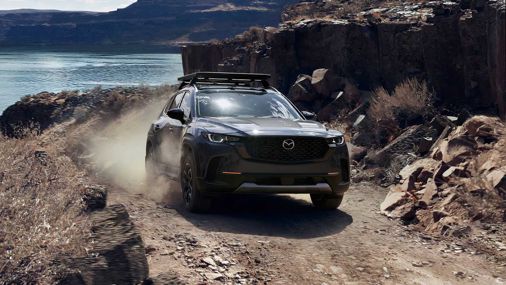 2025 Mazda CX-50, frente 3/4 subindo colina rochosa