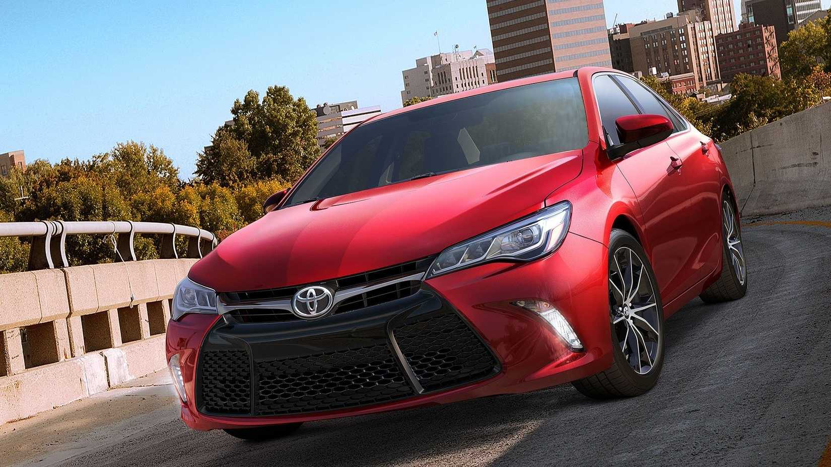 Front 3/4 shot of a red 2015 Toyota Camry driving in the city