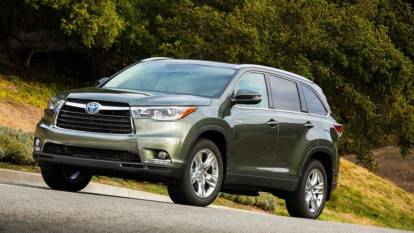A green 2015 Toyota Highlander Hybrid midsize hybrid SUV is parked. 