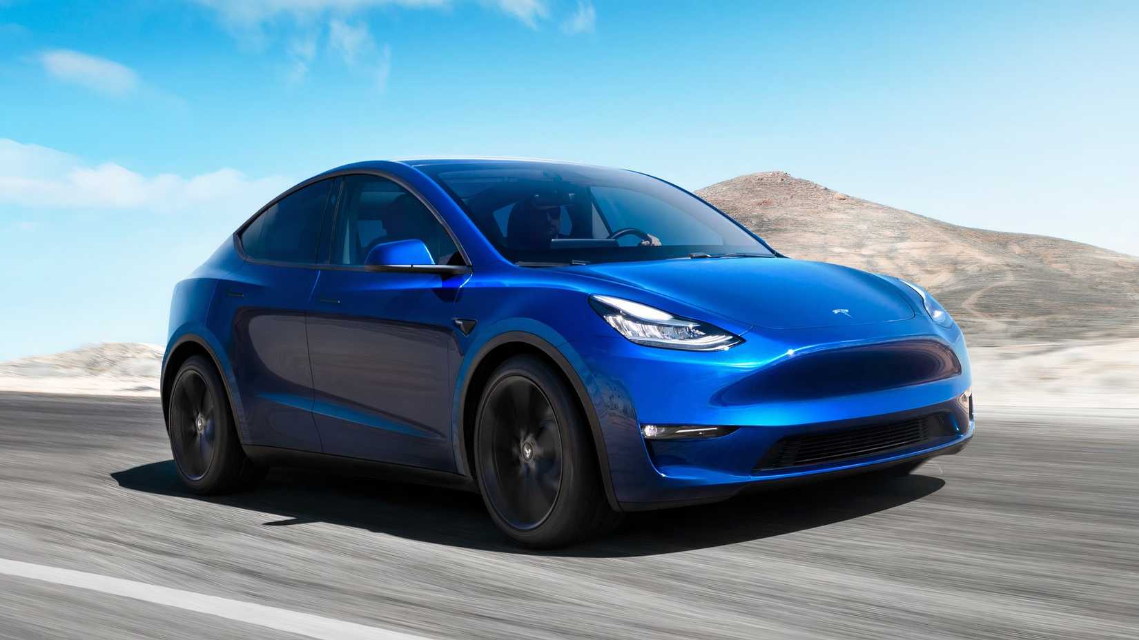Front three-quarters action shot of a blue 2020 Tesla Model Y