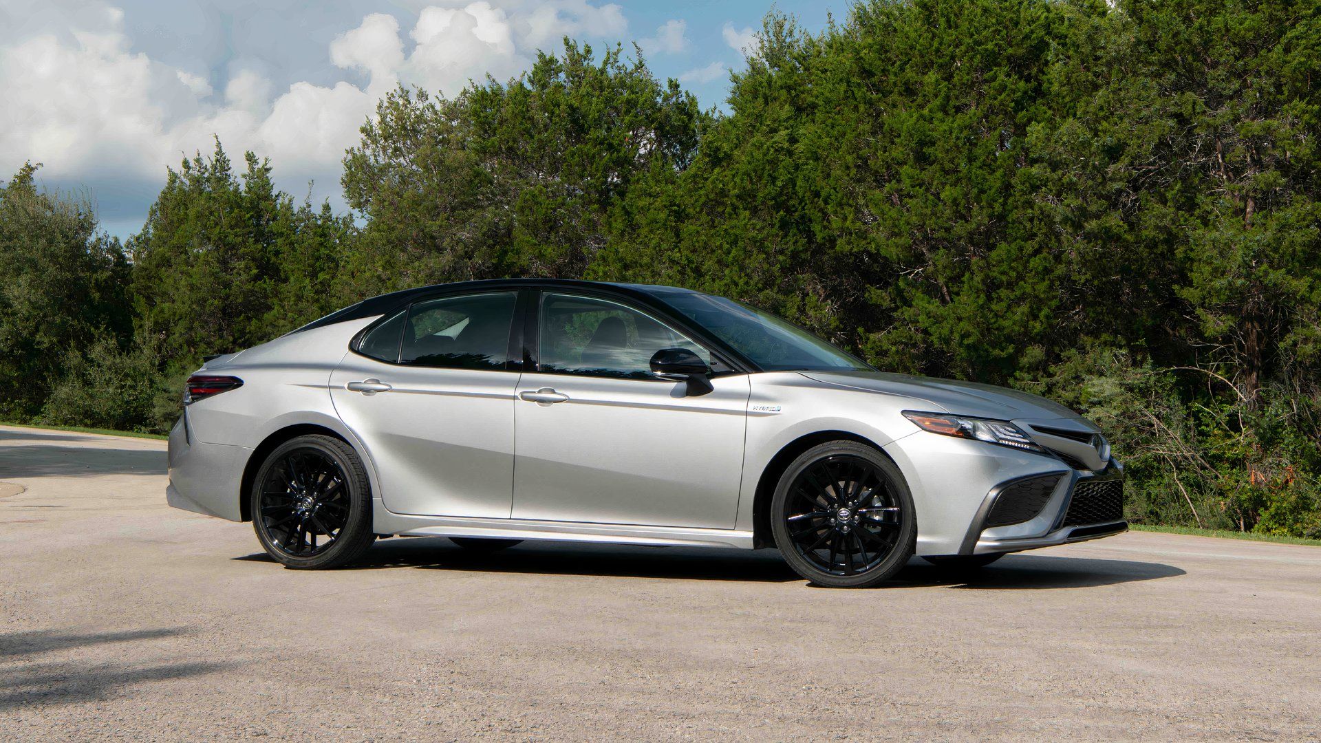 Side profile shot of a silver 2022 Toyota Camry Hybrid